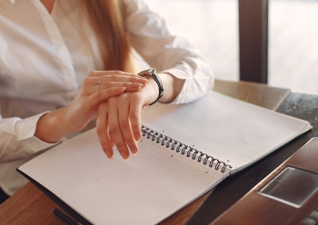 A business woman is managing her time accurately while looking at her watch in the office